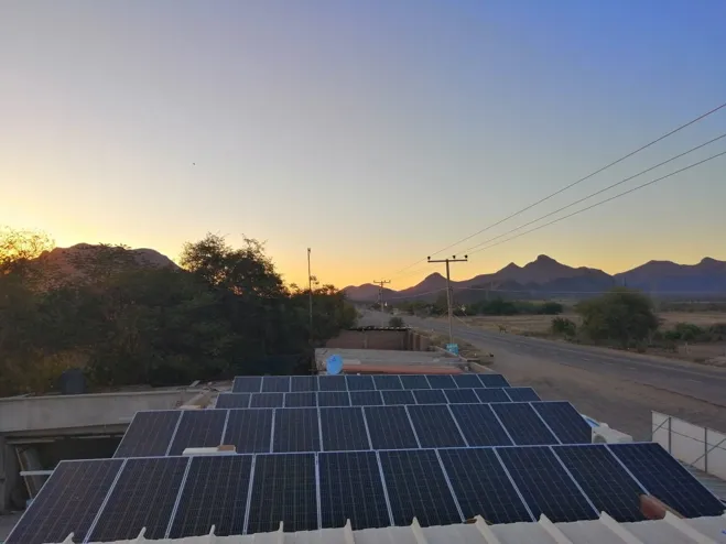 Planta solar al atardecer junto a carretera